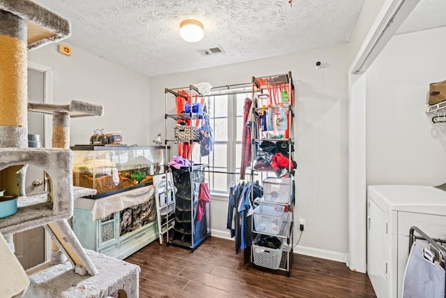 interior space featuring washer / clothes dryer, a healthy amount of sunlight, visible vents, and wood finished floors