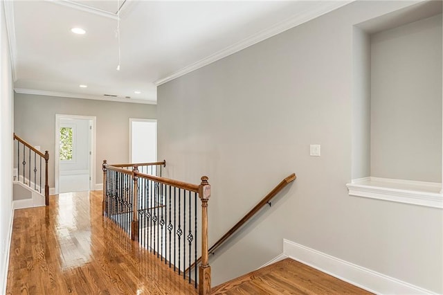 staircase with wood-type flooring and crown molding