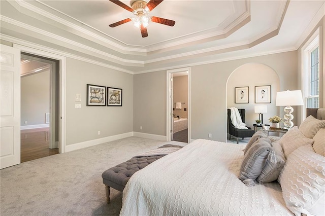 bedroom featuring crown molding, carpet flooring, ceiling fan, and a tray ceiling