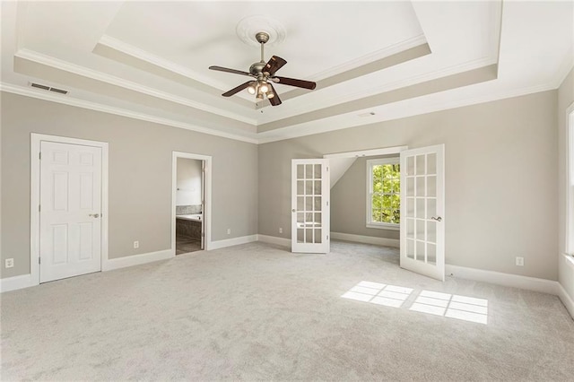 unfurnished bedroom featuring french doors, connected bathroom, light colored carpet, and a raised ceiling