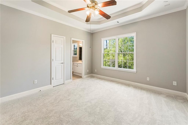 carpeted spare room featuring ceiling fan, a raised ceiling, and ornamental molding