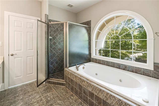 bathroom featuring tile flooring, independent shower and bath, and a wealth of natural light