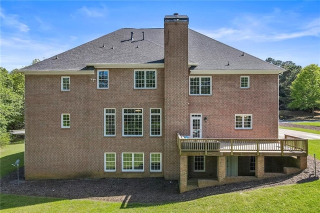 rear view of property with a lawn and a wooden deck