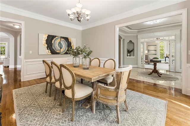 dining room with crown molding, an inviting chandelier, and hardwood / wood-style floors