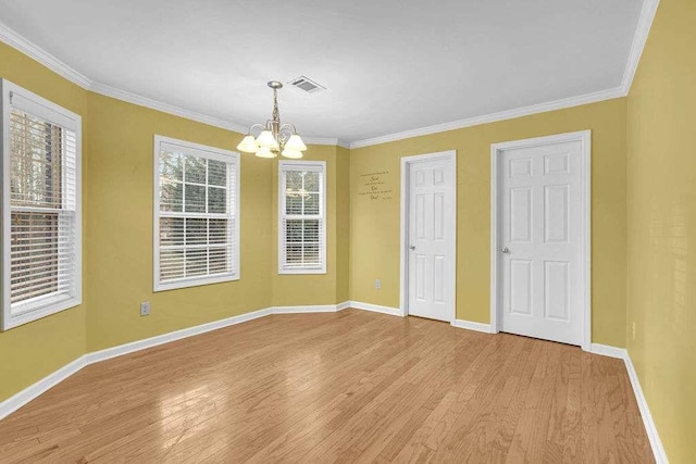 unfurnished room with light wood-type flooring, an inviting chandelier, and crown molding