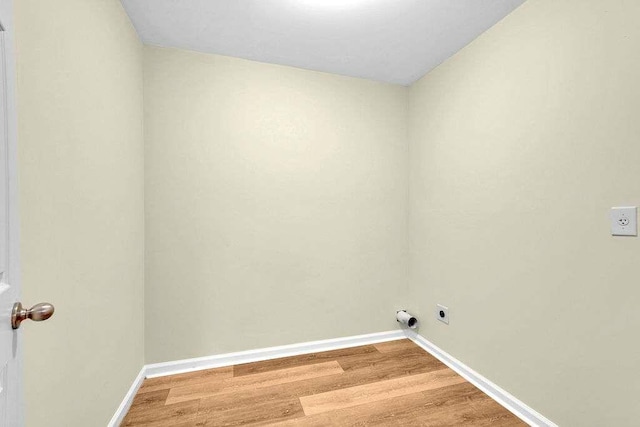 clothes washing area featuring hookup for an electric dryer and hardwood / wood-style flooring