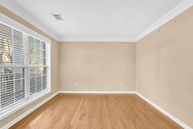 spare room featuring light hardwood / wood-style flooring and ornamental molding