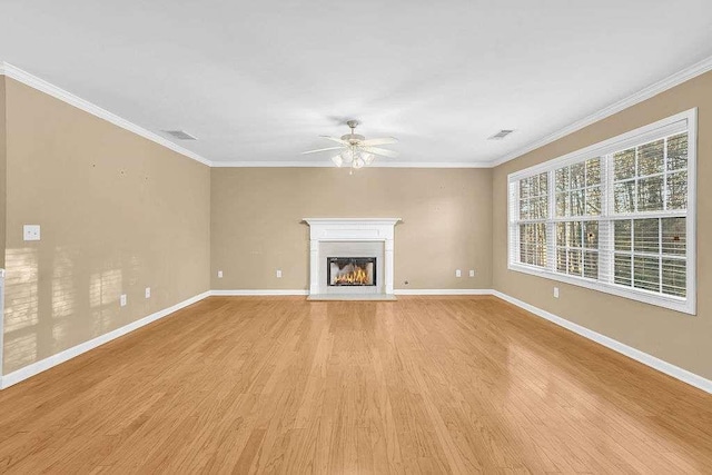 unfurnished living room with ceiling fan, ornamental molding, and light hardwood / wood-style flooring