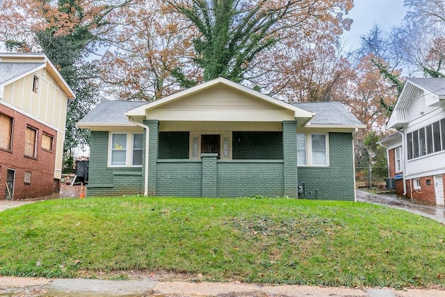 bungalow-style home with central AC unit, a porch, and a front lawn