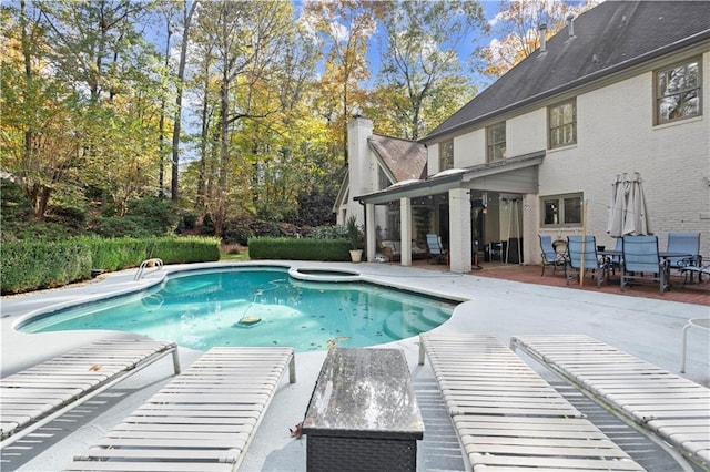 view of pool featuring a pool with connected hot tub and a patio area