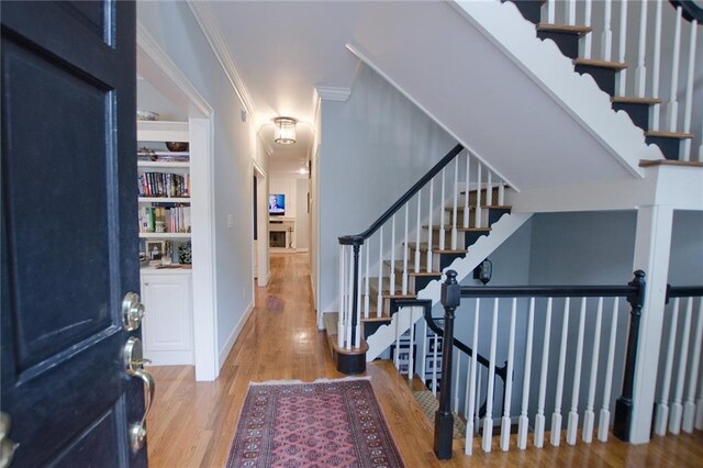 entryway featuring light hardwood / wood-style flooring and crown molding