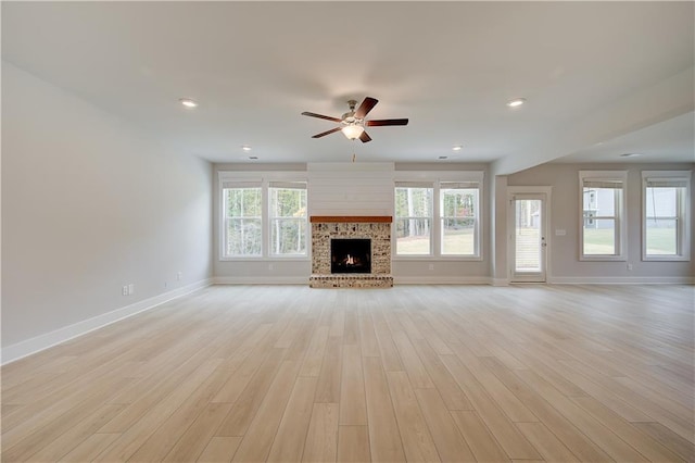 unfurnished living room with ceiling fan, light wood-type flooring, and a wealth of natural light