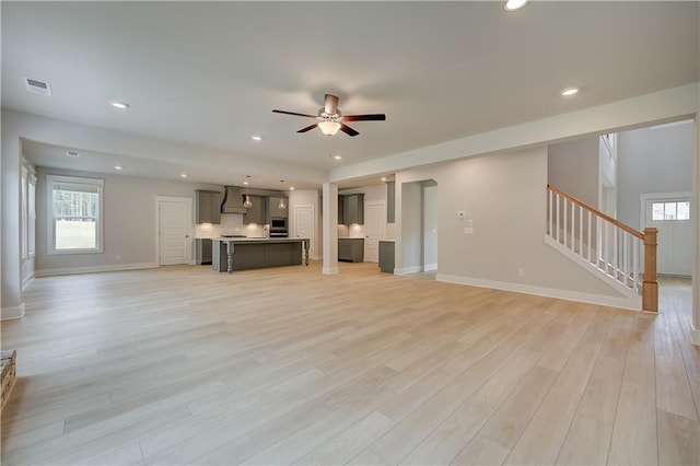 unfurnished living room featuring light hardwood / wood-style floors and ceiling fan