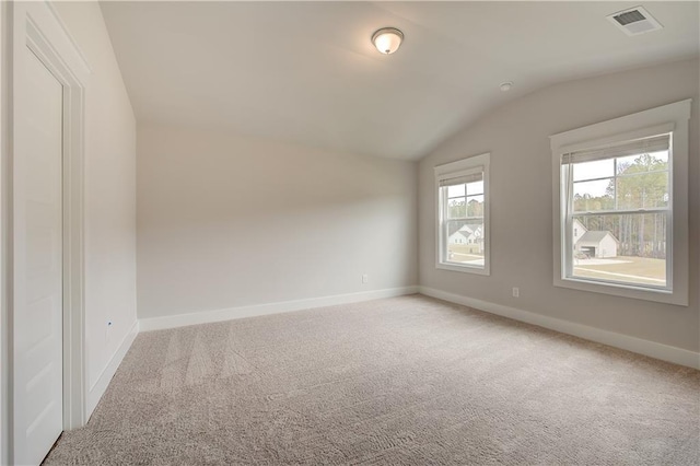 carpeted spare room featuring lofted ceiling