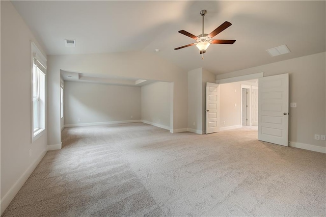 interior space featuring ceiling fan, light carpet, and lofted ceiling