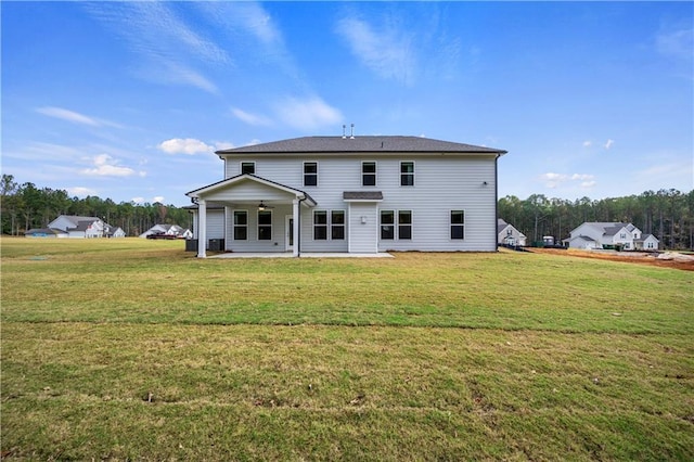 back of property featuring a yard, ceiling fan, and a patio area