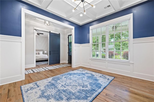 313 Sisson Ave NE, Atlanta, GA 30317 - bedroom featuring a decorative wall, a barn door, coffered ceiling, wood finished floors, and wainscoting
