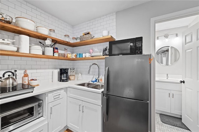 313 Sisson Ave NE, Atlanta, GA 30317 - kitchen featuring freestanding refrigerator, open shelves, black microwave, a sink, and tasteful backsplash