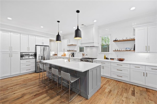 313 Sisson Ave NE, Atlanta, GA 30317 - kitchen with stainless steel refrigerator with ice dispenser, a breakfast bar, white cabinets, tasteful backsplash, and light wood-type flooring