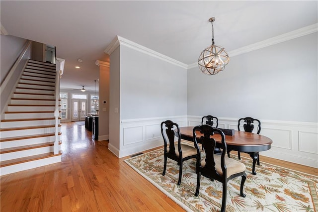 359 Alderwood Ln, Atlanta, GA 30328 - dining area featuring stairway, a chandelier, ornamental molding, light wood-style flooring, and wainscoting