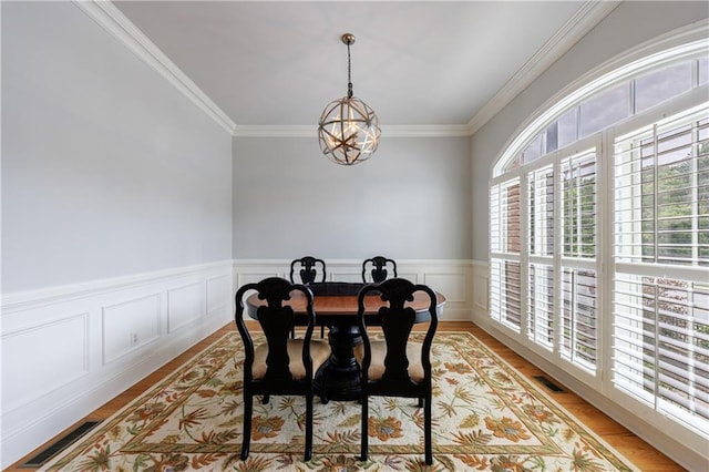 359 Alderwood Ln, Atlanta, GA 30328 - dining room featuring a chandelier, ornamental molding, light wood finished floors, and a wainscoted wall