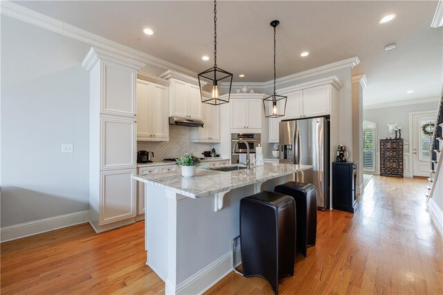359 Alderwood Ln, Atlanta, GA 30328 - kitchen featuring stainless steel appliances, white cabinetry, a center island with sink, decorative backsplash, and light stone countertops