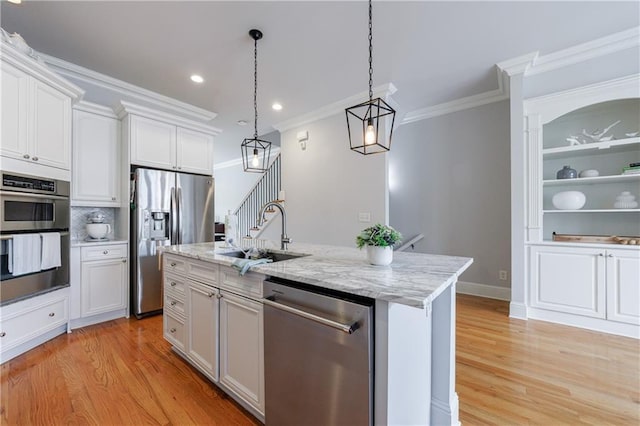 359 Alderwood Ln, Atlanta, GA 30328 - kitchen featuring appliances with stainless steel finishes, a sink, light wood-style floors, crown molding, and decorative light fixtures