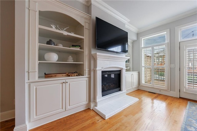 359 Alderwood Ln, Atlanta, GA 30328 - unfurnished living room featuring light wood-style floors, crown molding, a glass covered fireplace, built in features, and baseboards