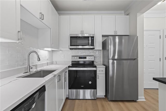 401 16th St NW Unit 1357, Atlanta, GA 30363 - kitchen featuring stainless steel appliances, white cabinets, light wood-style flooring, and ornamental molding