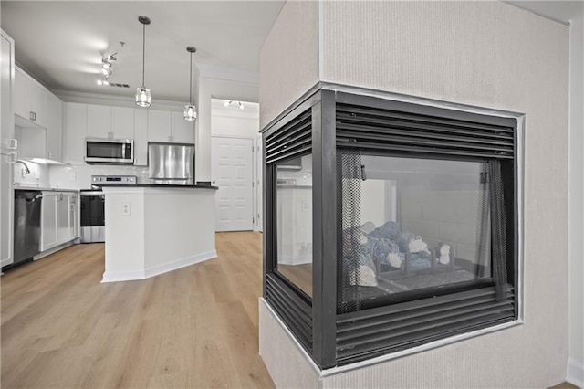 401 16th St NW Unit 1357, Atlanta, GA 30363 - kitchen with appliances with stainless steel finishes, light wood-type flooring, white cabinetry, decorative light fixtures, and a kitchen island