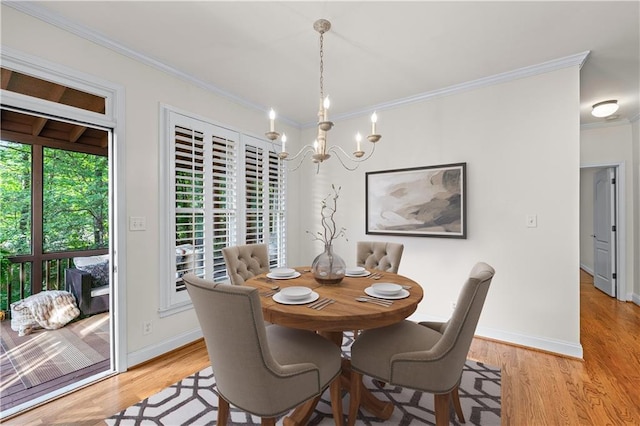 dining area featuring light wood-style floors, baseboards, ornamental molding, and a chandelier