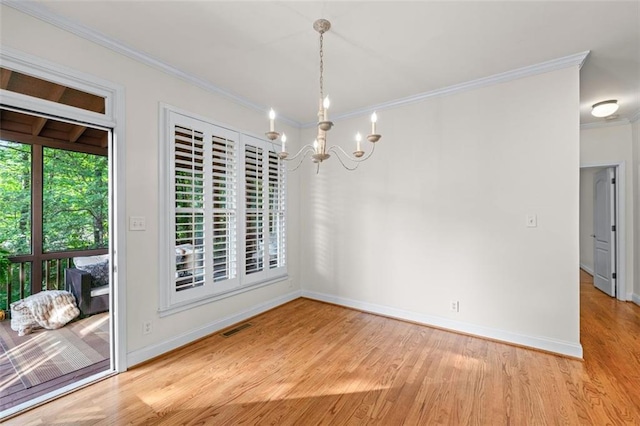 unfurnished dining area featuring visible vents, crown molding, wood finished floors, baseboards, and an inviting chandelier