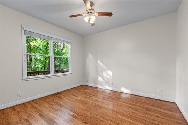 empty room featuring baseboards, a ceiling fan, wood finished floors, and visible vents
