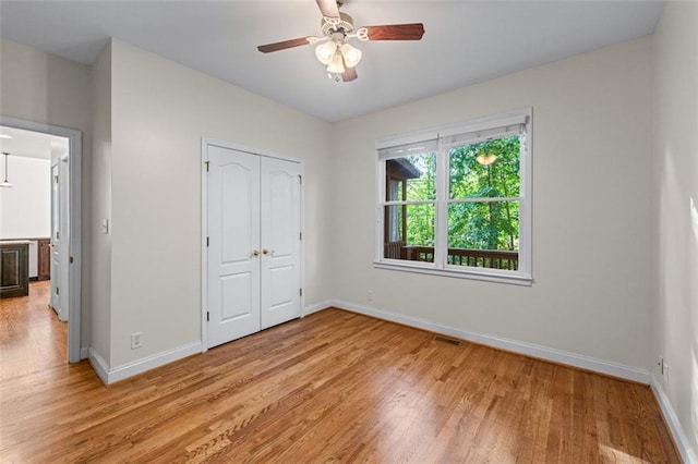 unfurnished bedroom featuring a closet, baseboards, visible vents, and light wood-type flooring