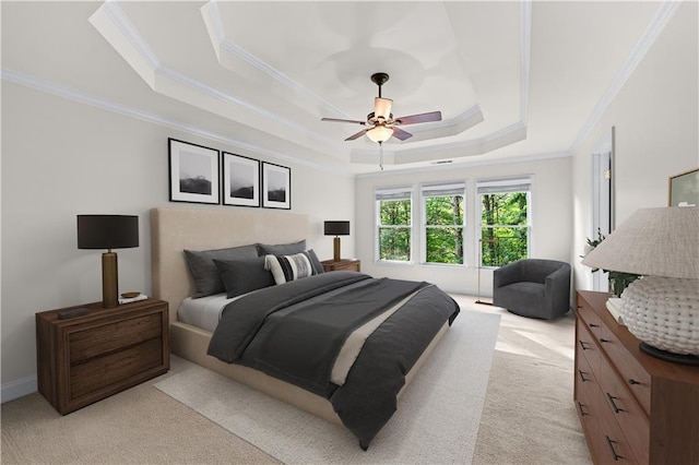 bedroom with a tray ceiling, a ceiling fan, ornamental molding, and light colored carpet