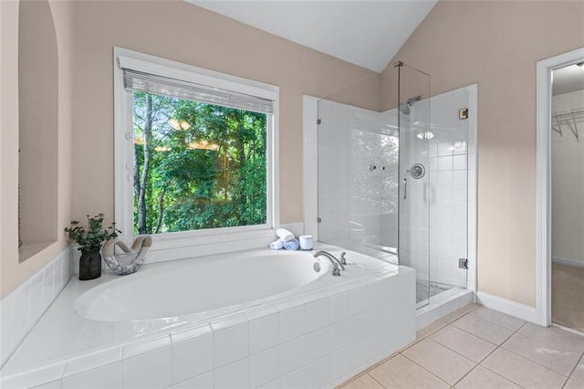 full bathroom featuring a garden tub, lofted ceiling, tile patterned floors, and a shower stall