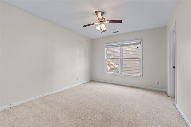 unfurnished room featuring baseboards, ceiling fan, visible vents, and light colored carpet