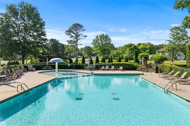 community pool featuring fence and a patio