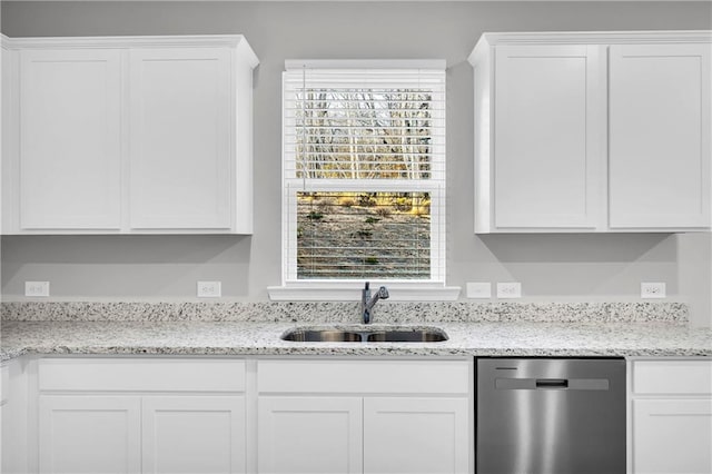 kitchen with sink, stainless steel dishwasher, white cabinetry, and light stone countertops