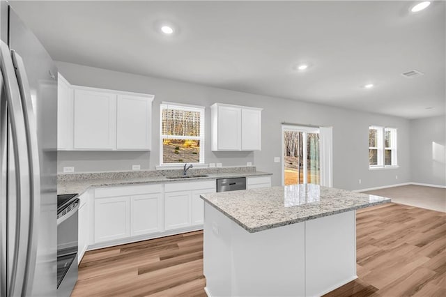 kitchen featuring white cabinets, a center island, and stainless steel appliances