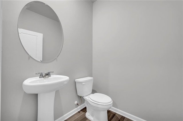 bathroom with hardwood / wood-style flooring, sink, and toilet