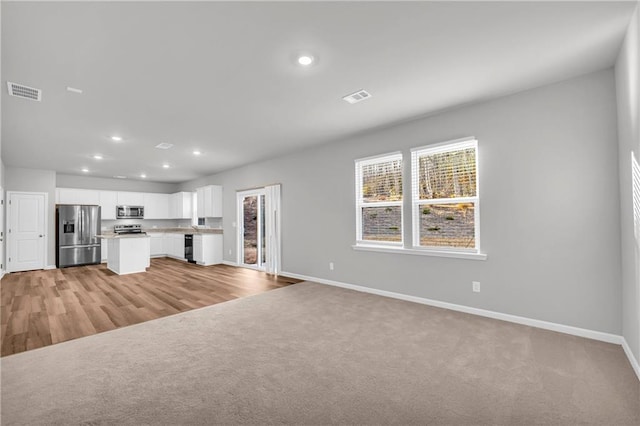 unfurnished living room with light colored carpet