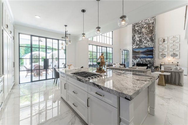 kitchen with stainless steel gas cooktop, plenty of natural light, marble finish floor, and a premium fireplace