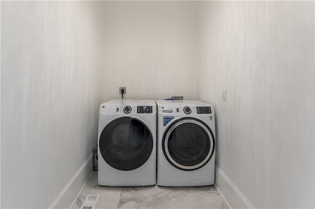 laundry area featuring baseboards, visible vents, washing machine and clothes dryer, laundry area, and marble finish floor