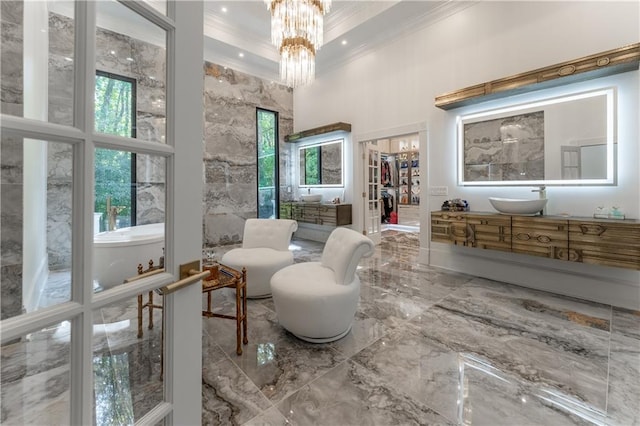 living area featuring ornamental molding, recessed lighting, a towering ceiling, a notable chandelier, and marble finish floor