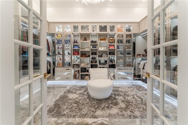 spacious closet with marble finish floor and french doors