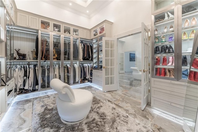 spacious closet with marble finish floor and a towering ceiling