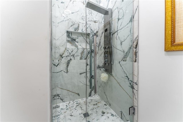 bathroom featuring a marble finish shower