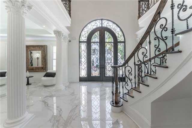 entryway with stairs, french doors, a high ceiling, marble finish floor, and ornate columns