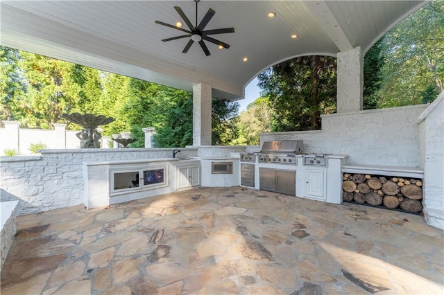 view of patio featuring ceiling fan, a grill, an outdoor kitchen, and fence